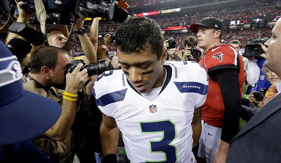 Seahawks quarterback Russell Wilson leaves the field after shaking hands with Atlanta Falcons quarterback Matt Ryan after an NFC divisional playoff NFL football game Sunday, Jan. 13, 2013, in Atlanta. The Falcons won 30-28. (AP Photo/David Goldman)