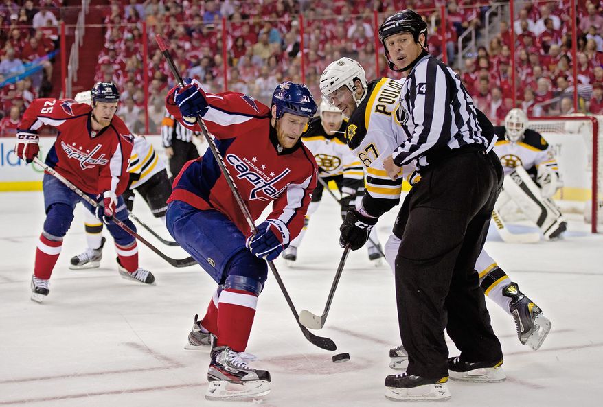 Capitals center Brooks Laich battles for the puck with Bruins left wing Benoit Pouliot during Game 3 of the opening-round playoff series last April. (Andrew Harnik/The Washington Times)