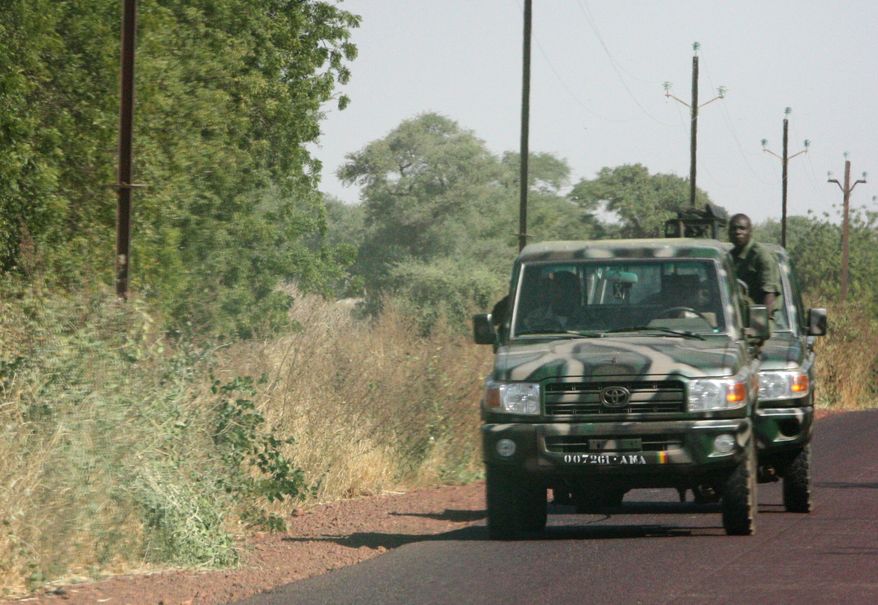 Malian soldiers drive toward the garrison village of Diabaly, on the road near Markala, approximately 25 miles outside Segou in central Mali, on Monday, Jan. 14, 2013. Despite intensive aerial bombardments by French warplanes, Islamist insurgents grabbed more territory in the West African country on Monday and got much closer to the capital, French and Malian authorities said. In the latest setback, the al-Qaeda-linked extremists overran Diabaly, France's defense minister said in Paris. (AP Photo/Harouna Traore)