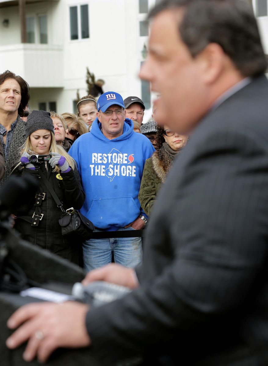 Bill Pahlck wears a "Restore The Shore" sweatshirt Wednesday morning as he and others in Belmar, N.J., listen to Gov. Chris Christie describe rebuilding plans. The governor helped Belmar officials kick off construction of a 1.3-mile boardwalk to replace the one destroyed by Superstorm Sandy in October. (Associated Press)