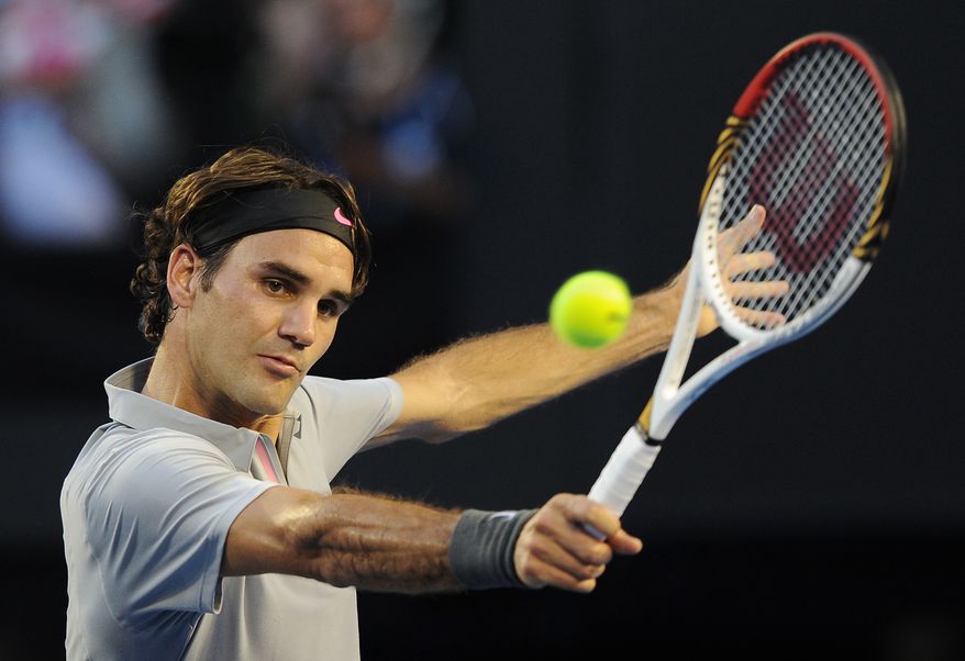 Switzerland's Roger Federer makes a backhand return to Russia's Nikolay Davydenko during their second round match at the Australian Open tennis championship in Melbourne, Australia, Thursday, Jan. 17, 2013. (AP Photo/Andrew Brownbill)