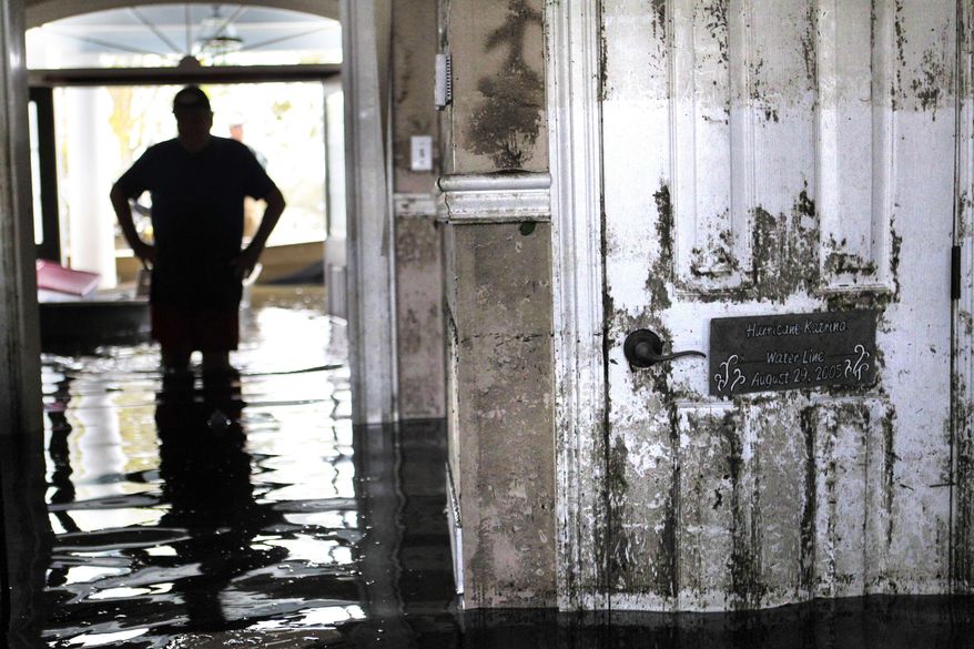 ** FILE ** In this Sept. 2, 2012, file photo, Don Duplantier walks through his flooded home as water recedes from Hurricane Isaac in Braithwaite, La. (AP Photo/Gerald Herbert, File)