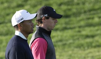Rory McIlroy from Northern Ireland, right, and Tiger Woods from U.S. walk on the 13th hole during the first round of Abu Dhabi Golf Championship in Abu Dhabi, United Arab Emirates, Thursday, Jan. 17, 2013. (AP Photo/Kamran Jebreili)