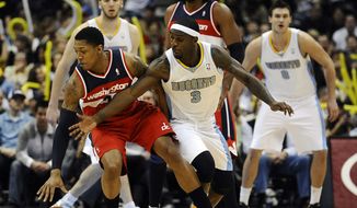Denver Nuggets guard Ty Lawson, right, tries to steal the ball from Washington Wizards guard Bradley Beal, left, in the second half of an NBA basketball game between the Washington Wizards and the Denver Nuggets on Friday, Jan. 18, 2013, in Denver. The Wizards won 112-108. (AP Photo/Chris Schneider)