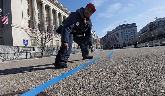 Worker Rodney Hart, prepares the street on Pennsylvania Avenue in front of the White House, Sunday, Jan. 20, 2013, in Washington. Thousands will march during the 57th Presidential Inauguration parade after the ceremonial swearing-in of President Barack Obama on Monday. (AP Photo/Gerald Herbert)
