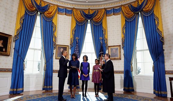 President Barack Obama is officially sworn-in by Chief Justice John Roberts in the Blue Room of the White House during the 57th Presidential Inauguration in Washington, Sunday, Jan. 20, 2013. Next to Obama are first lady Michelle Obama, holding the Robinson Family Bible, and daughters Malia and Sasha. (AP Photo/Larry Downing, Pool)