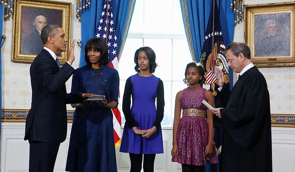 President Barack Obama is officially sworn-in by Chief Justice John Roberts in the Blue Room of the White House during the 57th Presidential Inauguration in Washington, Sunday Jan. 10, 2013. Next to Obama are first lady Michelle Obama, holding the Robinson Family Bible, and daughters Malia and Sasha. (AP Photo/Larry Downing, Pool)