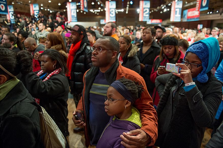 Volunteers Andre Livingston and his daughter Rayna, 10, center, of Ellicott City, Md., listen with other volunteers as Vice President Joseph Biden takes the stage to speak to the volunteers putting together service packages for members of the armed services abroad during the National Day of Service at the D.C. Armory, Washington, D.C., Saturday, January 19, 2013. Non-profit groups are running hundreds of service projects for the Martin Luther King Jr. weekend. (Andrew Harnik/The Washington Times)