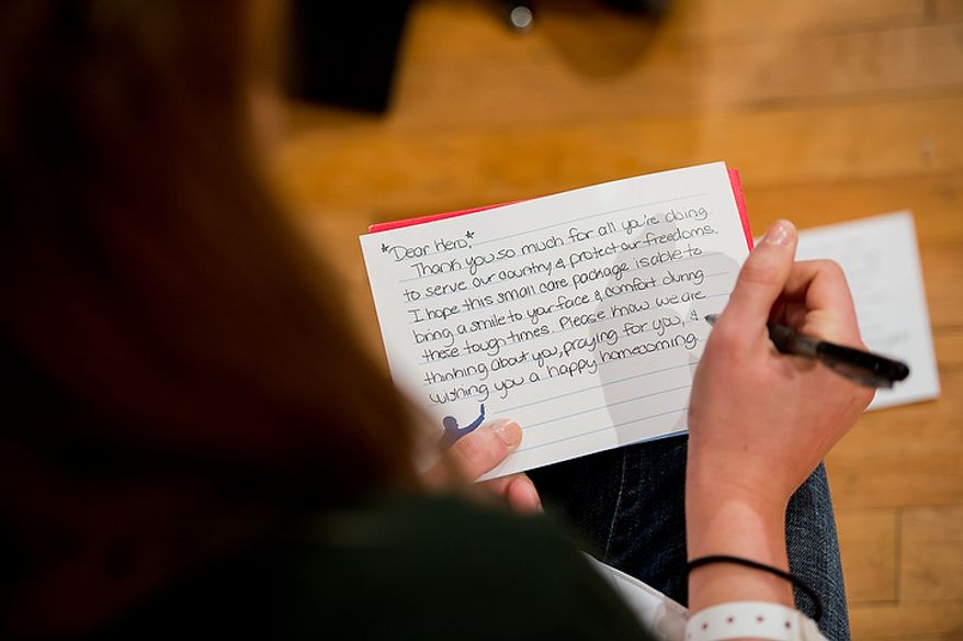 Volunteer Shannon Stinson of Fairfax, Va., writes a handwritten letter to a service member to go along with service packages for members of the armed services abroad during the National Day of Service at the D.C. Armory, Washington, D.C., Saturday, January 19, 2013. Non-profit groups are running hundreds of service projects for the Martin Luther King Jr. weekend. (Andrew Harnik/The Washington Times)