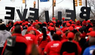 A group carries letters spelling &quot;BELIEVE&quot; as they take part in a march honoring Martin Luther King Jr., on Monday in San Antonio. (Associated Press)