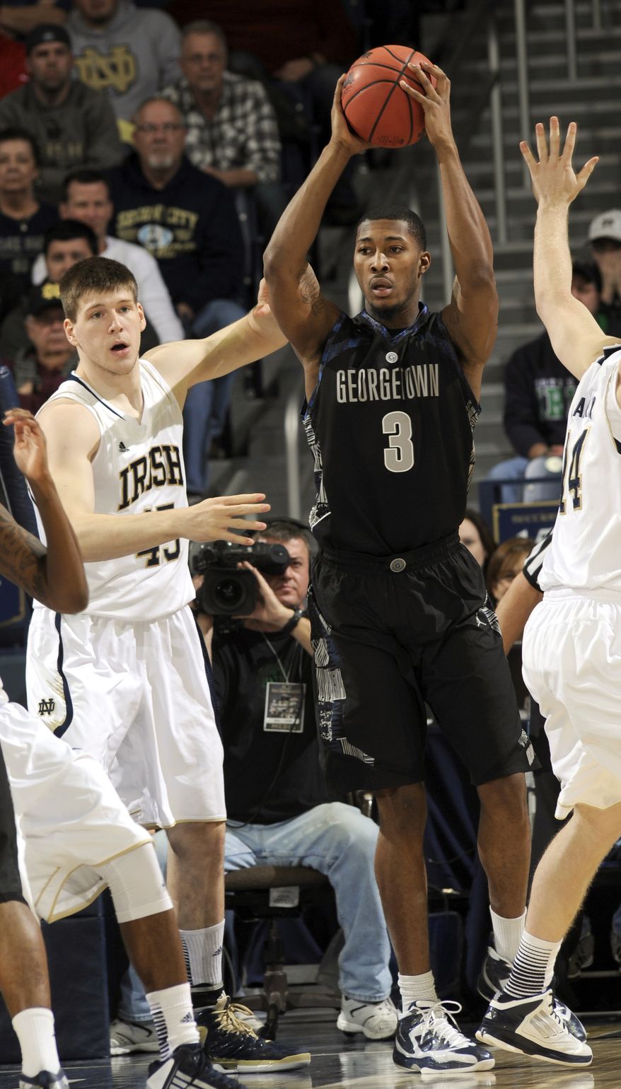 Georgetown forward Mikael Hopkins (3) throws a pass around Notre Dame forward Jack Cooley during the first half of Georgetown's 63-47 win on Jan. 21, 2013, in South Bend, Ind. (Associated Press)