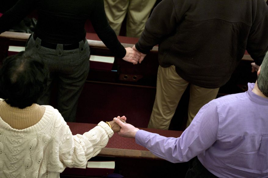 Parishioners hold hands as they sing the song "We Shall Overcome" at the end of an interfaith service at Newtown Congregational Church in Newtown, Conn., Sunday, Jan. 20, 2013. (AP Photo/Jessica Hill)