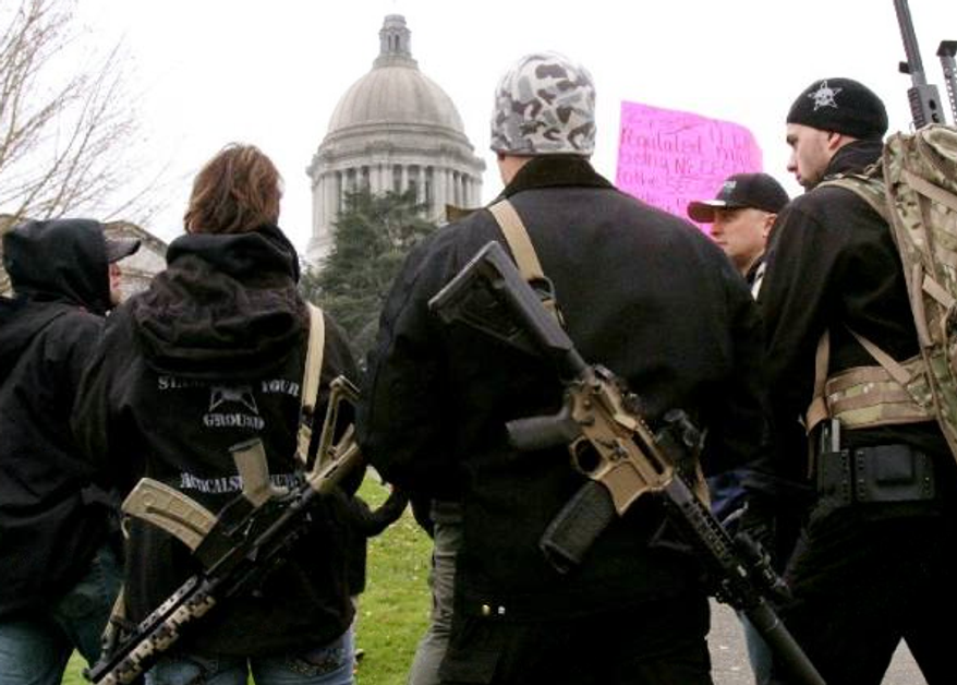 ** FILE ** Members of a Yakima, Wash., weapons seller carry firearms to a Second Amendment rally near the state Capitol in Olympia, Wash., on Saturday, Jan. 19, 2013. (Seattle Times via Associated Press)