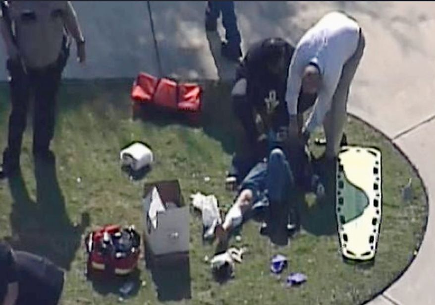 Emergency personnel attend to an unidentified person at Lone Star College on Tuesday, Jan. 22, 2013, in Houston. Law enforcement officials say the community college is locked down amid reports of a shooter on campus. (AP Photo/Courtesy of KPRC-TV)