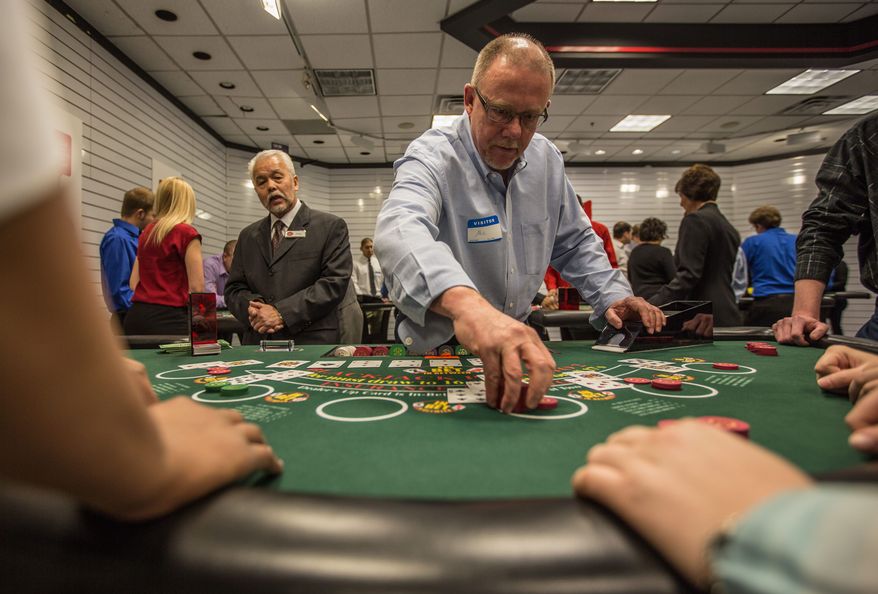 Mel Lorton practices how to properly run a game during training for those seeking jobs as casino dealers at Maryland Live Casino. The training school is in a store at the Marley Station Mall in Glen Burnie, Md. The school is just one step in the selection process. (Andrew S. Geraci/The Washington Times)
