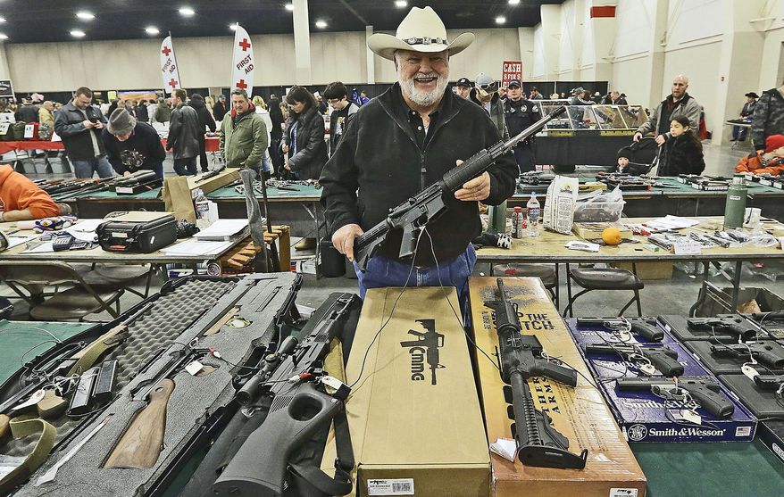 Ken Haiterman shows off a CMMG 5.56mm AR 15 at the 2013 Rocky Mountain Gun Show on Jan. 6 in Sandy, Utah. In spite of the recent school shootings in Newtown, Conn., gun enthusiasts flocked to the show to purchase weapons and ammunition. (Associated Press)