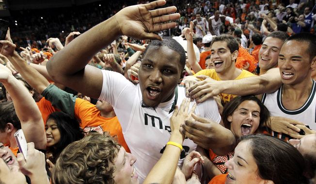 Miami&#x27;s Reggie Johnson celebrates with fans after defeating Duke 90-63 in an NCAA college basketball game in Coral Gables, Fla., Wednesday, Jan. 23, 2013. (AP Photo/The Miami Herald, Charlie Trainor) 