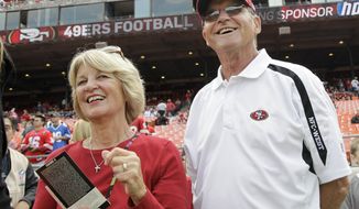 ** FILE ** In this Sept. 11, 2011 file photo, Jackie and Jack Harbaugh, parents of San Francisco 49ers coach Jim Harbaugh and Baltimore Ravens coach John Harbaugh, stand before an NFL football game between the 49ers and the Seattle Seahawks in San Francisco. The entire Harbaugh family already got its Super Bowl victory last Sunday, when each coach did his part to ensure a family reunion in New Orleans next week. The Ravens face off against the 49ers in the first Super Bowl coached by siblings on opposite sidelines. (AP Photo/Paul Sakuma)