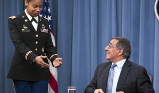 Army Lt. Col. Tamatha Patterson of Huntingdon, Tenn., waits for Defense Secretary Leon E. Panetta to hand her the memorandum he has just signed ending the 1994 ban on women serving in combat on Jan. 24, 2013, during a news conference at the Pentagon. (Associated Press)