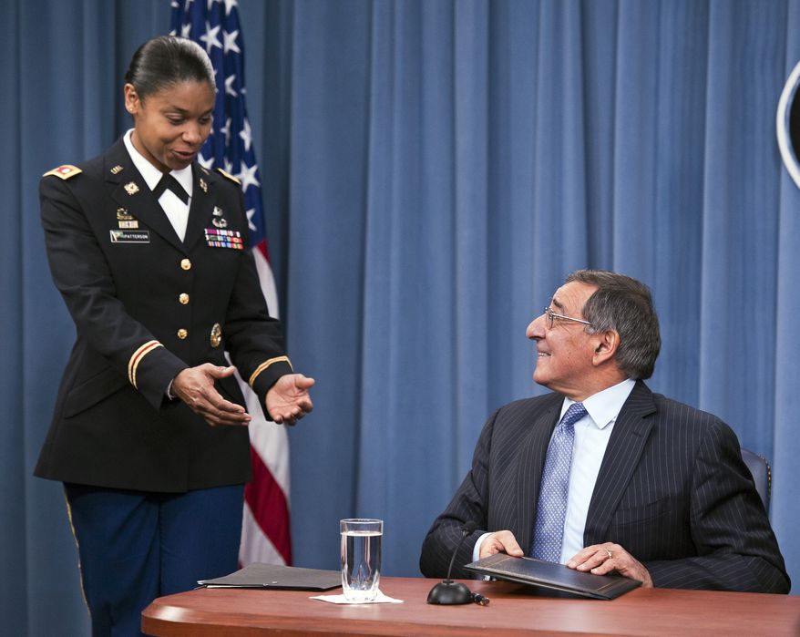 Army Lt. Col. Tamatha Patterson of Huntingdon, Tenn., waits for Defense Secretary Leon E. Panetta to hand her the memorandum he has just signed ending the 1994 ban on women serving in combat on Jan. 24, 2013, during a news conference at the Pentagon. (Associated Press)
