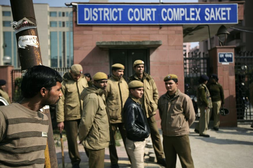 Delhi policemen stand guard Jan. 24, 2013, near the gate of a district court in New Delhi, where the trial of the five men charged accused in the gang rape and murder of a 23-year-old student began in a closed courtroom. (Associated Press)