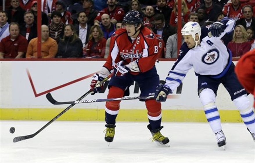 Washington Capitals left wing Alex Ovechkin (8) from Russia, battle for the puck with Winnipeg Jets center Olli Jokinen (12) from Finland, in the first period of an NHL hockey game Tuesday, Jan. 22, 2013 in Washington. (AP Photo/Alex Brandon)