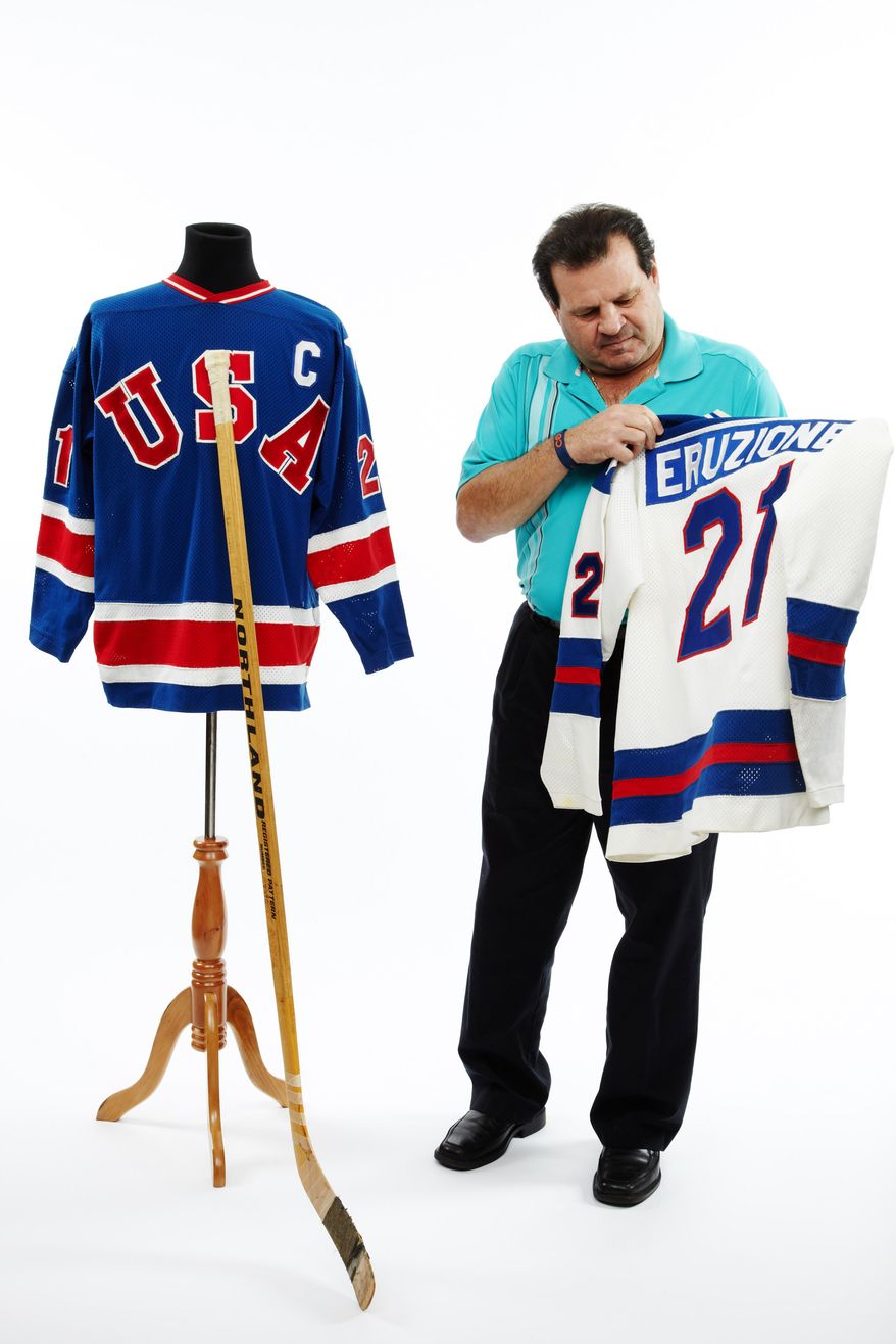 Mike Eruzione, the captain of the 1980 "Miracle on Ice" Olympic hockey team, poses with the game sweaters and stick he putting up for auction.