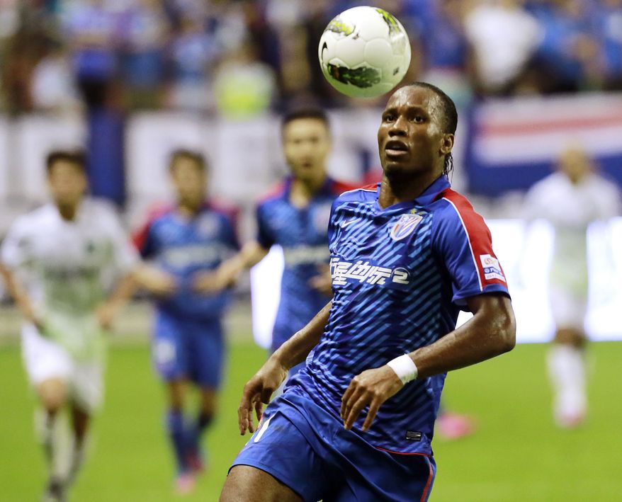 FILE - In this Aug. 4, 2012 file photo, Shanghai Shenhua's Didier Drogba controls the ball during a soccer match against Hangzhou Greentown at Hongkou Football Stadium in Shanghai. (AP Photo/Eugene Hoshiko, File)