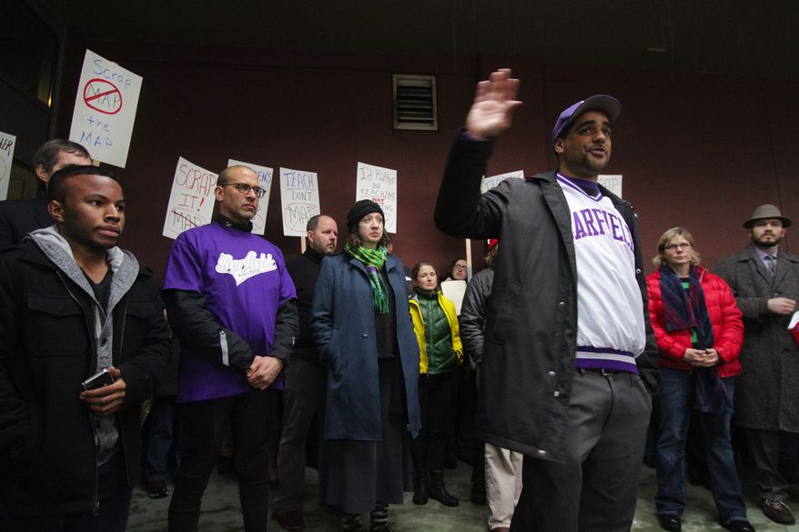 Garfield High School social studies teacher Jesse Hagopian (with his hand raised) and other Seattle teachers are refusing to administer to their students a standardized test they say is flawed. (Seattle Times via Associated Press)