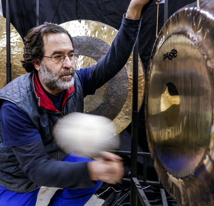 Andrew Borakove of Gongs Unlimited strikes a gong in his warehouse in Lincoln, Neb. The former comedy writer from California counts Roger Daltry of The Who among his customers. (Associated Press)