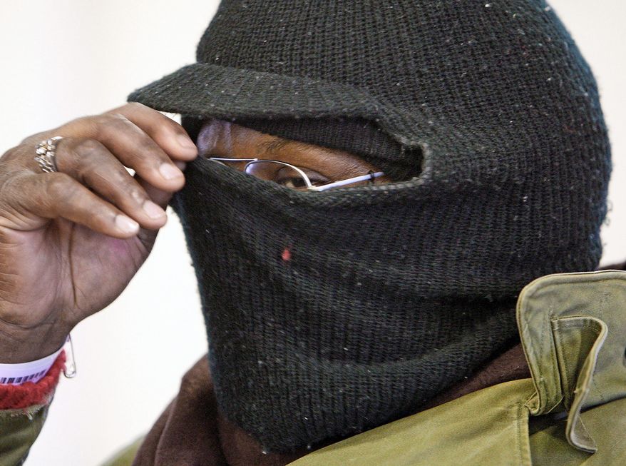 **FILE** Darryl Sey pulls his ski mask up higher as he waits in freezing temperatures for a bus to take him home on Jan. 7, 2010 in Nashville, Tenn. (Associated Press)