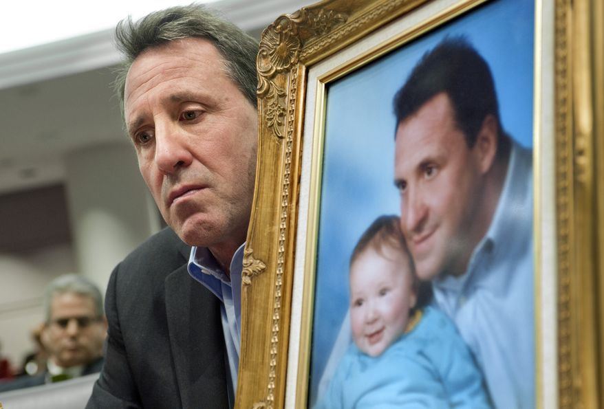 ** FILE ** Neil Heslin, holding a picture of himself with son Jesse, testifies before a legislative subcommittee hearing on gun laws in Hartford, Conn., on Monday, Jan. 28, 2013. (AP Photo/Jessica Hill)