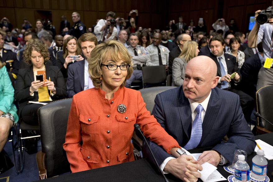 ** FILE ** Former Rep. Gabrielle Giffords, who was seriously injured in a mass shooting that killed six people in Tucson, Ariz., in 2011, sits with her husband, Mark Kelly, a retired astronaut, on Capitol Hill in Washington on Wednesday, Jan. 30, 2013, before speaking before the Senate Judiciary Committee hearing on what lawmakers should do to curb gun violence in the wake of the December shooting rampage that killed 20 schoolchildren in Newtown, Conn. (AP Photo/J. Scott Applewhite)