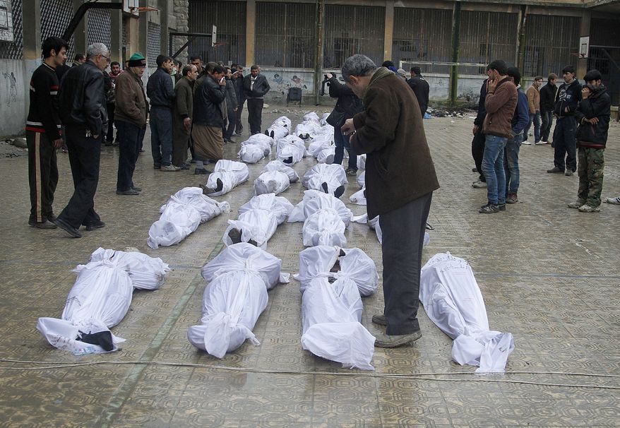 Syrian citizens search Jan. 30, 2013, in the neighborhood of Bustan al-Qasr in Aleppo for their relatives amongst dead bodies found next to a river the previous day. (Associated Press)