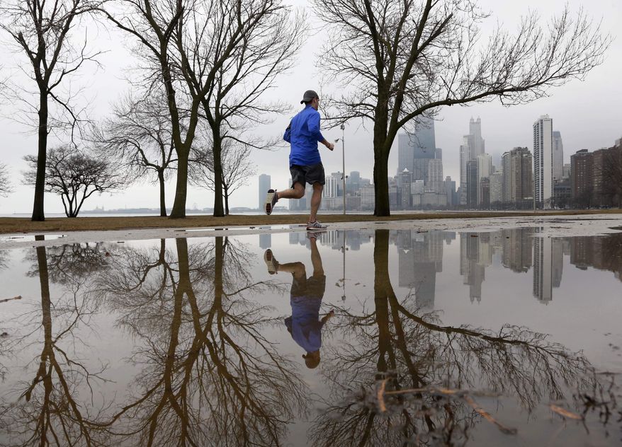 A lone jogger makes his way along Lake Michigan in unseasonably warm temperatures at Chicago's North Avenue Beach Tuesday, Jan. 29, 2013, in Chicago. Unseasonably warm temperatures broke records in the Chicago area with thunderstorm expected to usher in freezing temperatures and snow Wednesday. (AP Photo/Charles Rex Arbogast)