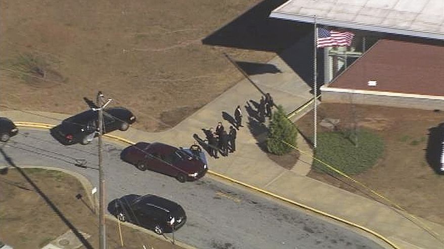 In this image made from video and released by WSB-TV, authorities investigate the scene of a school shooting on Jan 31, 2013 in Atlanta. Authorities say a 14-year-old has been wounded in a shooting at an Atlanta middle school and a suspect has been taken into custody. Atlanta police spokesman Carlos Campos says the wounded student has been taken "alert, conscious and breathing" to Grady Hospital. (Associated Press/WSB-TV)