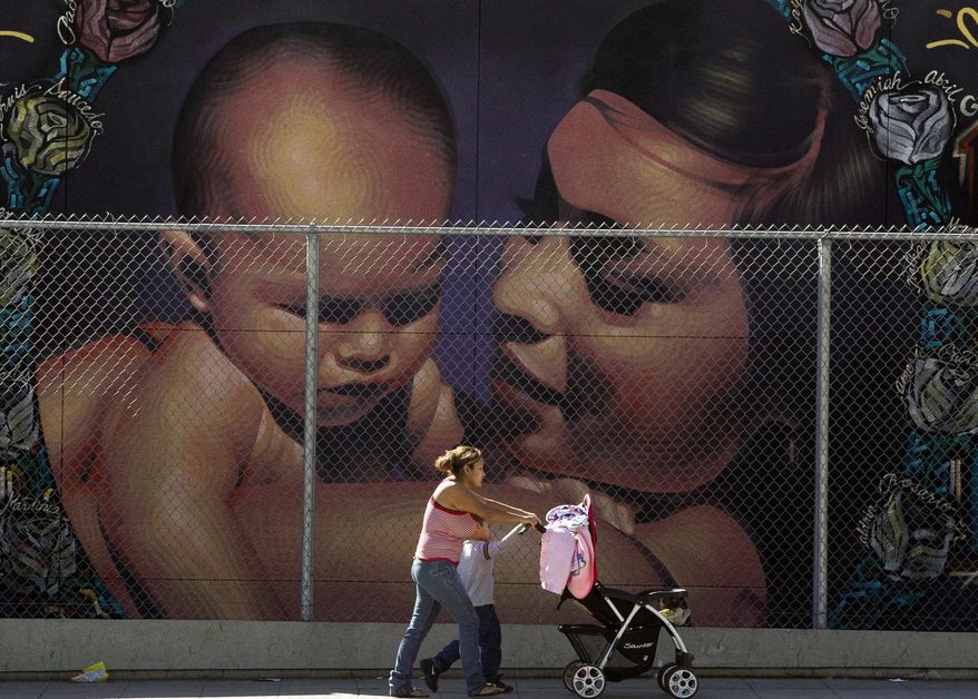 A mother walks with her children to the MacArthur Park Primary Center School in Los Angeles Thursday, Jan. 31, 2013. Within six months, California's Hispanic population will equal that of whites and soon after will surpass it, a milestone in the country's shifting demographics. (AP Photo/Damian Dovarganes)