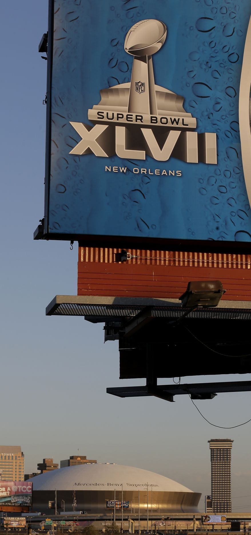 The Superdome is seen in the distance beyond a billboard Wednesday, Jan. 30, 2013, in New Orleans. The city will host the Super Bowl XLVII football game between the Baltimore Ravens and the San Francisco 49ers Sunday. (AP Photo/Charlie Riedel)