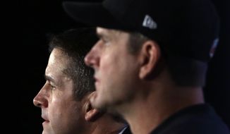 **FILE** Baltimore Ravens head coach John Harbaugh (left) and his younger brother, San Francisco 49ers head coach Jim Harbaugh, participate in a Feb. 1, 2013, news conference in New Orleans for Super Bowl XLVII. (Associated Press)