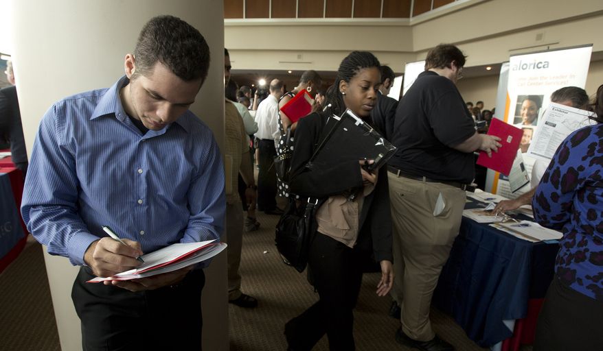 **FILE** Fernando Rames answers questions on a job application at the job fair in Sunrise, Fla., Jan. 22, 2013. (Associated Press)