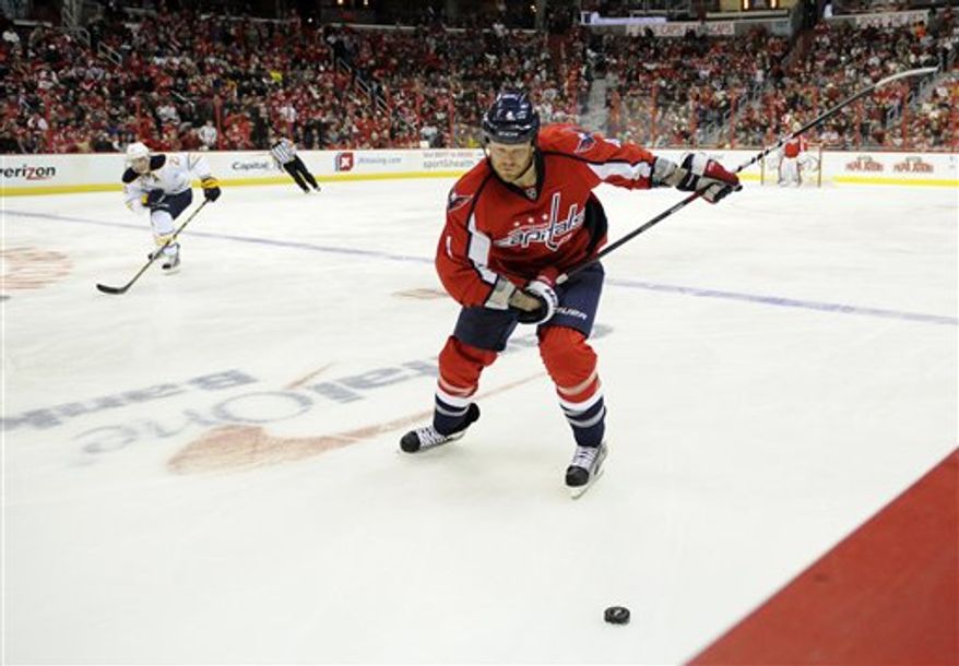 Washington Capitals defenseman John Erskine (4) chases the puck against the Buffalo Sabres during the second period of an NHL hockey game, Sunday, Jan. 27, 2013, in Washington. (AP Photo/Nick Wass)