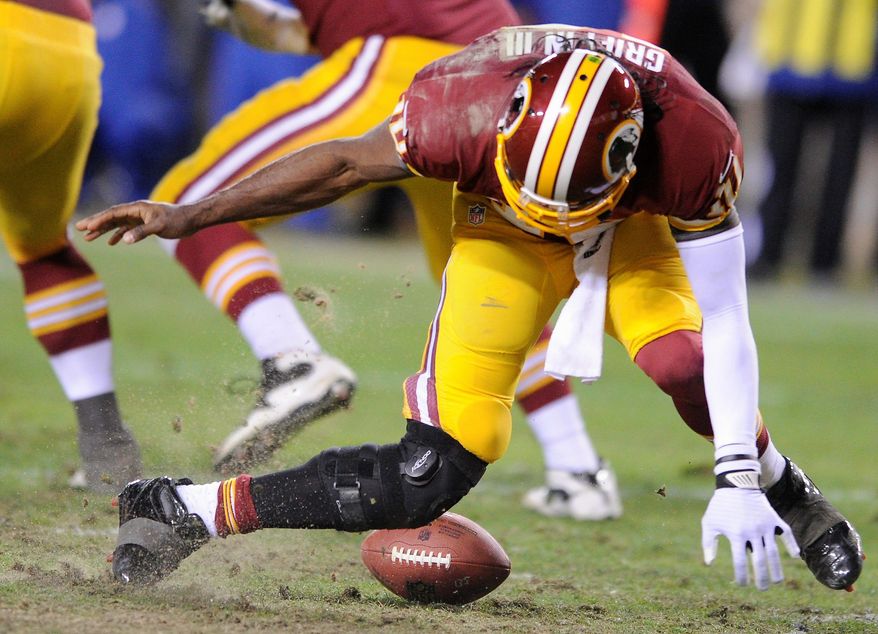 Washington Redskins quarterback Robert Griffin III (10) tries to pick up a fumbled snap in the fourth quarter and injures his leg in the NFC wild card game at FedEx Field, Landover, Md., Jan. 6, 2013. (Preston Keres/Special to The Washington Times)