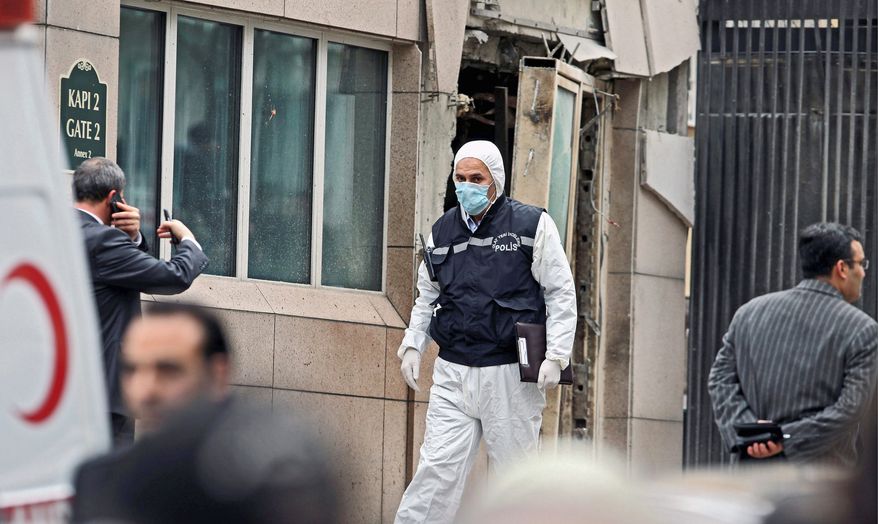 Emergency personnel are seen in front of a side entrance to the U.S. Embassy in Ankara, Turkey, after a suicide bomber detonated an explosive device there Friday. The blast also killed a Turkish security guard. (Associated Press)