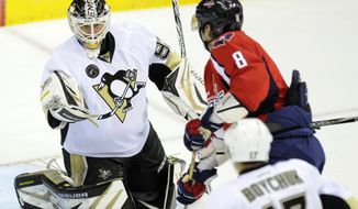 Pittsburgh Penguins goalie Tomas Vokoun (92) looks at the puck as Washington Capitals left wing Alex Ovechkin (8) looks on during the third period of an NHL hockey game on Sunday, Feb. 3, 2013, in Washington. The Penguins won 6-3. (AP Photo/Nick Wass)