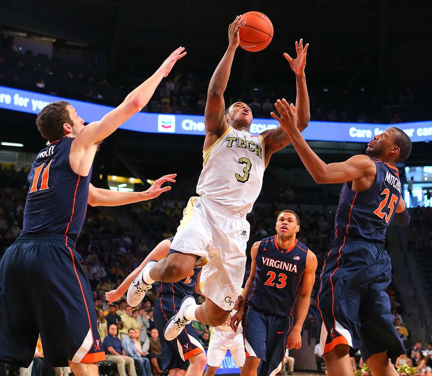 Georgia Tech guard Marcus Georges-Hunt leaps for a rebound over Virginia defenders Evan Nolte, left, Justin Anderson (23) and Akil Mitchell during the second half of their NCAA college basketball game on Sunday Feb. 3, 2013, in Atlanta. Georgia Tech battled back for a come from behind 66-60 victory to end Virginia's winning streak. (AP Photo/Atlanta Journal-Constitution, Curtis Compton)