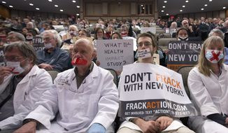 **FILE** Opponents of hydraulic fracturing, or fracking, demonstrate Jan. 30, 2013, in Albany, N.Y., as they sit in the audience as Dr. Nirav Shah, commissioner of the New York State Department of Health, testifies before a joint budget hearing on health and Medicaid. (Associated Press)