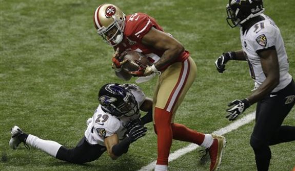 San Francisco 49ers wide receiver Michael Crabtree (15) makes a catch for a 31-yard touchdown as Baltimore Ravens cornerback Cary Williams (29) and safety Bernard Pollard (31) defend during the second half of the NFL Super Bowl XLVII football game Sunday, Feb. 3, 2013, in New Orleans. (AP Photo/Gerald Herbert) 