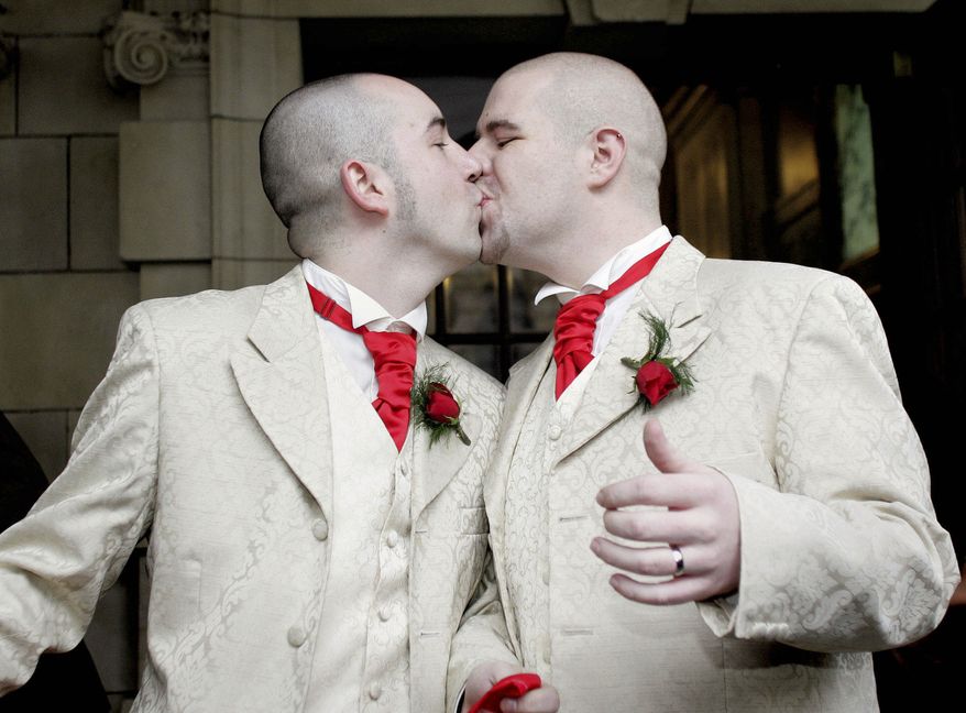 **FILE** Henry Edmont Cane (left) and partner Christopher Patrick Flanaghan kiss outside City Hall in Belfast, Northern Ireland, on Dec. 19, 2005. The two became the first male couple to win legal recognition for their partnership under a new British civil partnership law. (Associated Press)