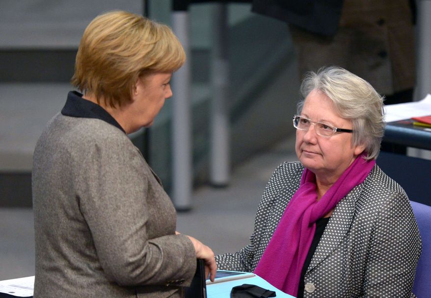 ** FILE ** in this Dec. 13, 2012, file photo German Chancellor Angela Merkel, left, talks to Education Minister Annette Schavan during a session of the German parliament Bundestag in Berlin, Germany. Schavan says she will not resign after a university stripped her of her doctorate because of plagiarism, and she vowed to fight the ruling. (AP Photo/dpa, Rainer Jensen, File)