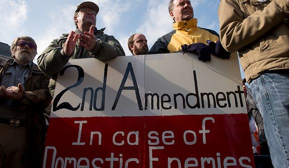 Jay Hanlon of Silver Spring, Md., second from left, and Mike Toeneboehn  of Annapolis, Md., second from right, hold a 2nd amendment sign as they listen to speakers at at a pro-gun rights rally against a proposal by Maryland Governor Martin O&#39;Malley that would ban assault weapons and require residents to obtain a license before purchasing handguns at Lawyers Park in front of the Maryland State House, Annapolis, Md., Wednesday, February 6, 2013. (Andrew Harnik/The Washington Times)
